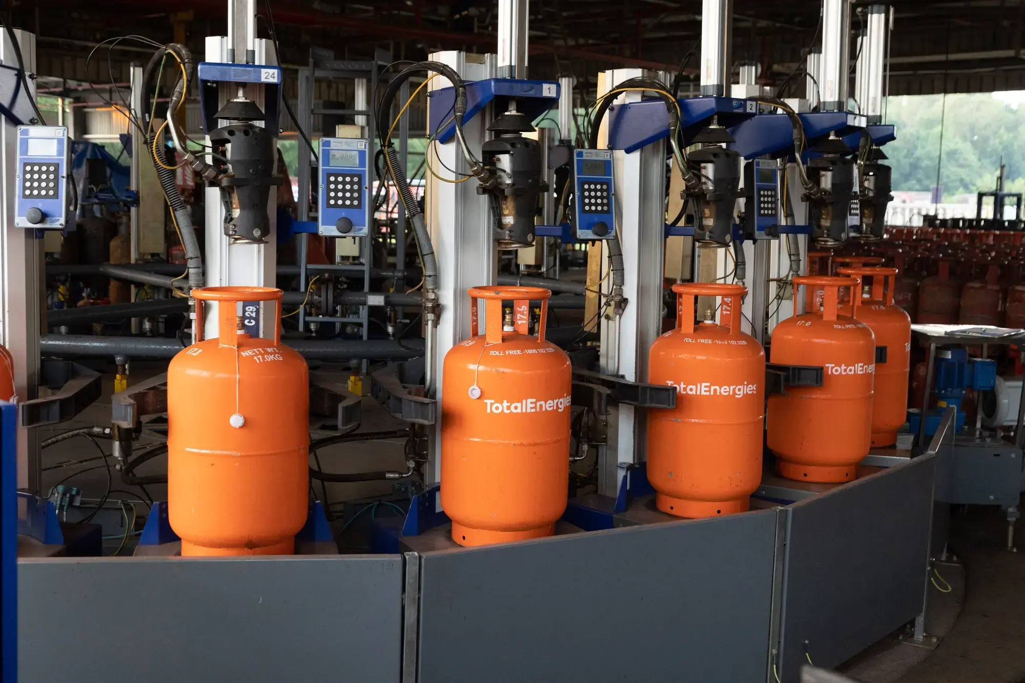 Orange TotalEnergies LPG cylinders at a bottling plant